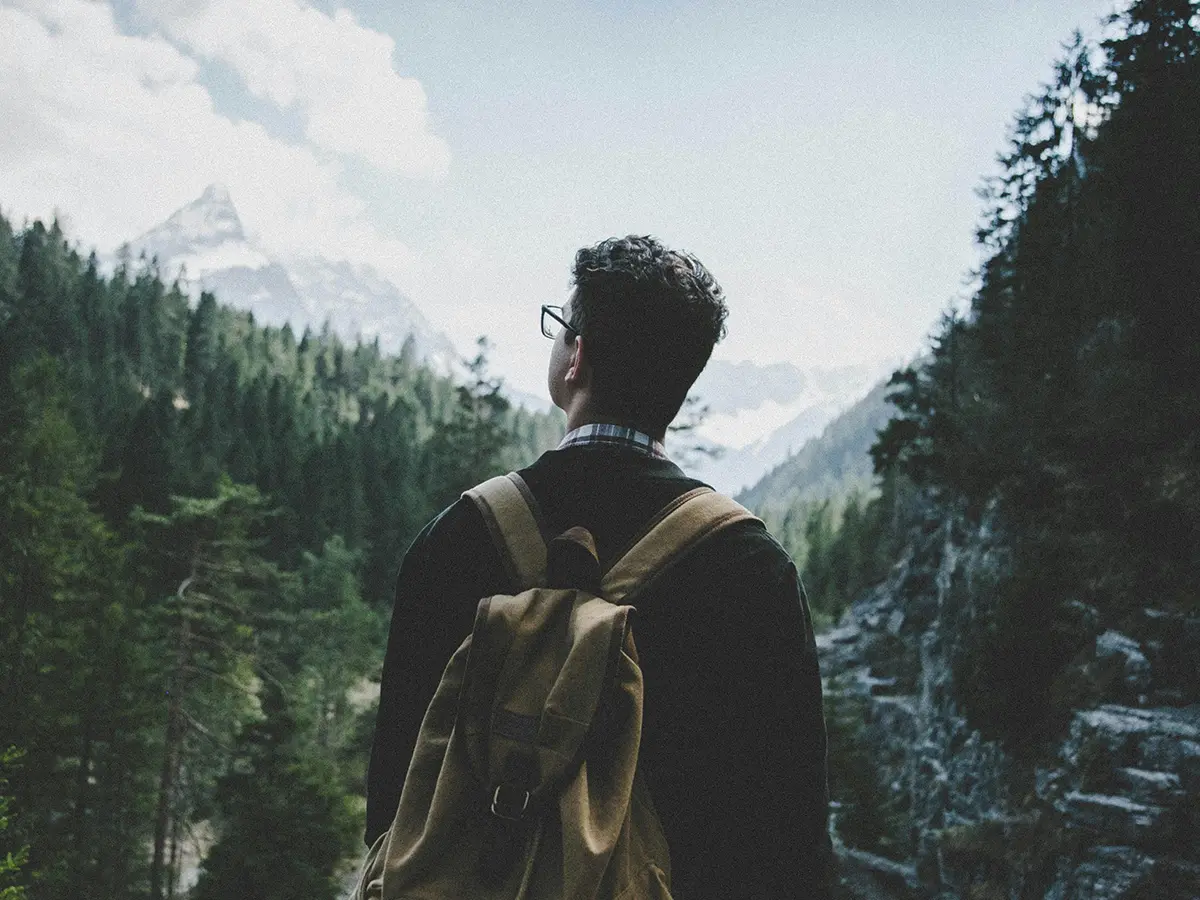 Viajero entre montañas observando el horizonte