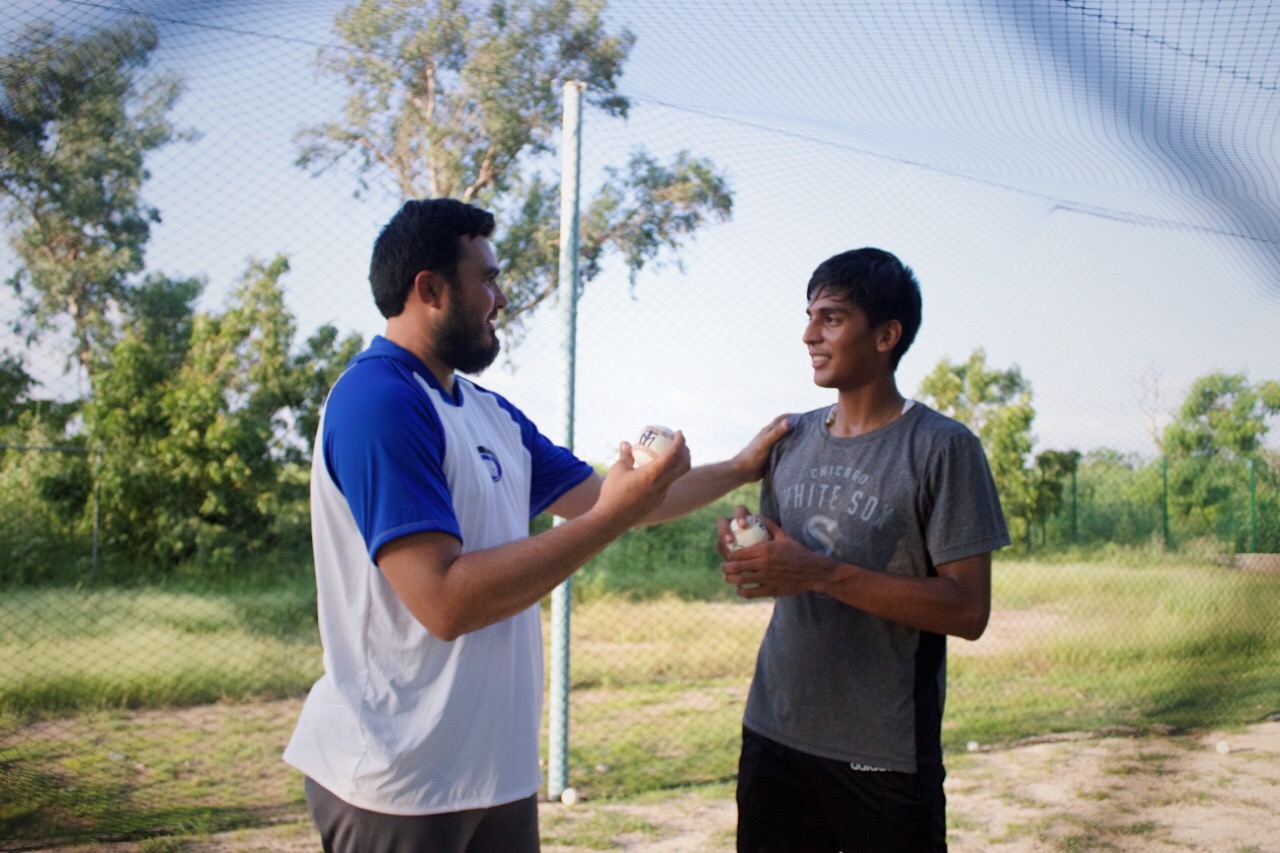 El entrenador Eduardo David León con su alumno de béisbol