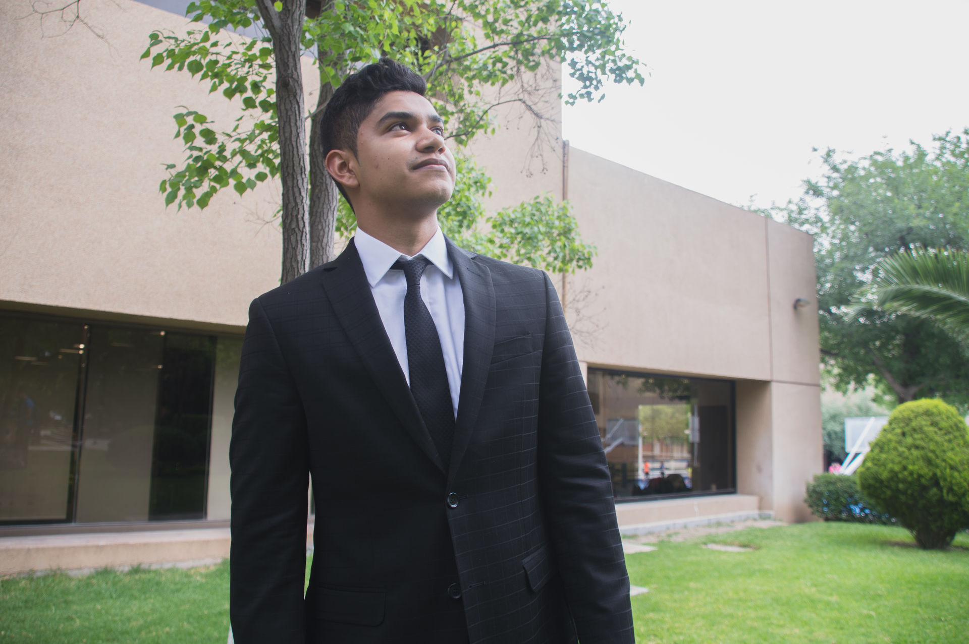 Joven de traje mirando hacia arriba