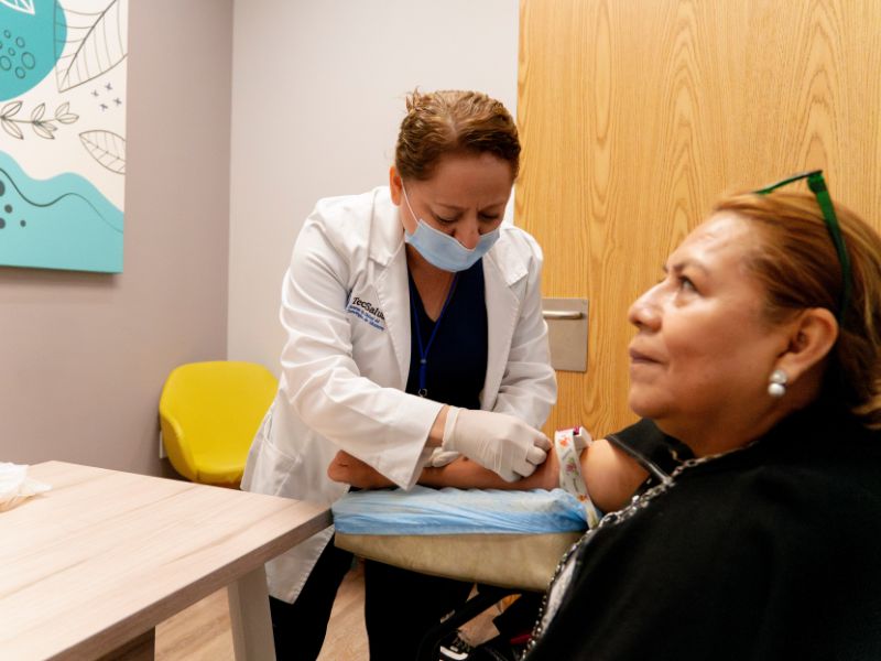 Enfermera obteniendo muestra de sangre de paciente de la Cl&iacute;nica ELA.