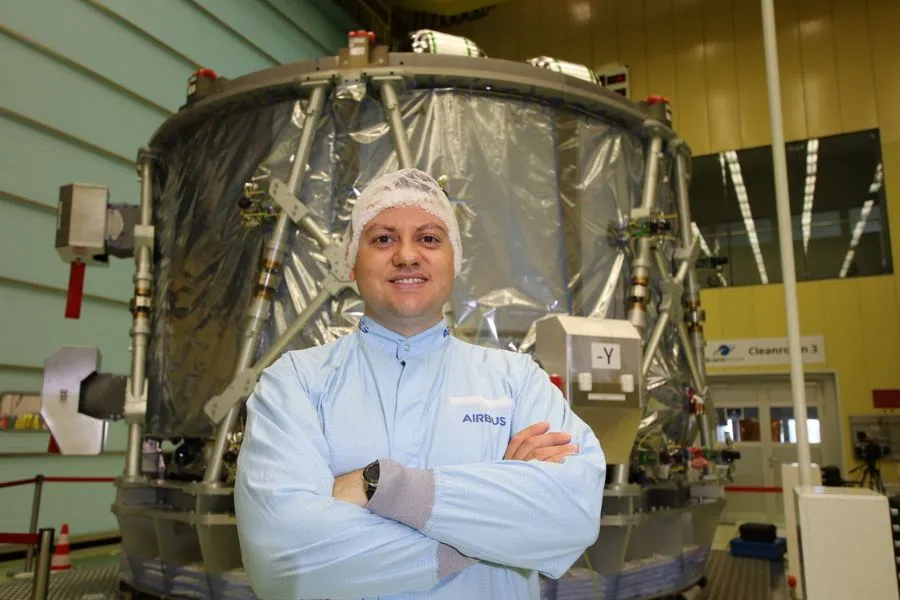 Gerardo Urrutia dentro de un cuarto limpio en Bremen, Alemania, posando frente al M&oacute;dulo de Servicio Europeo ESM-3, utilizado en la misi&oacute;n Artemis III.