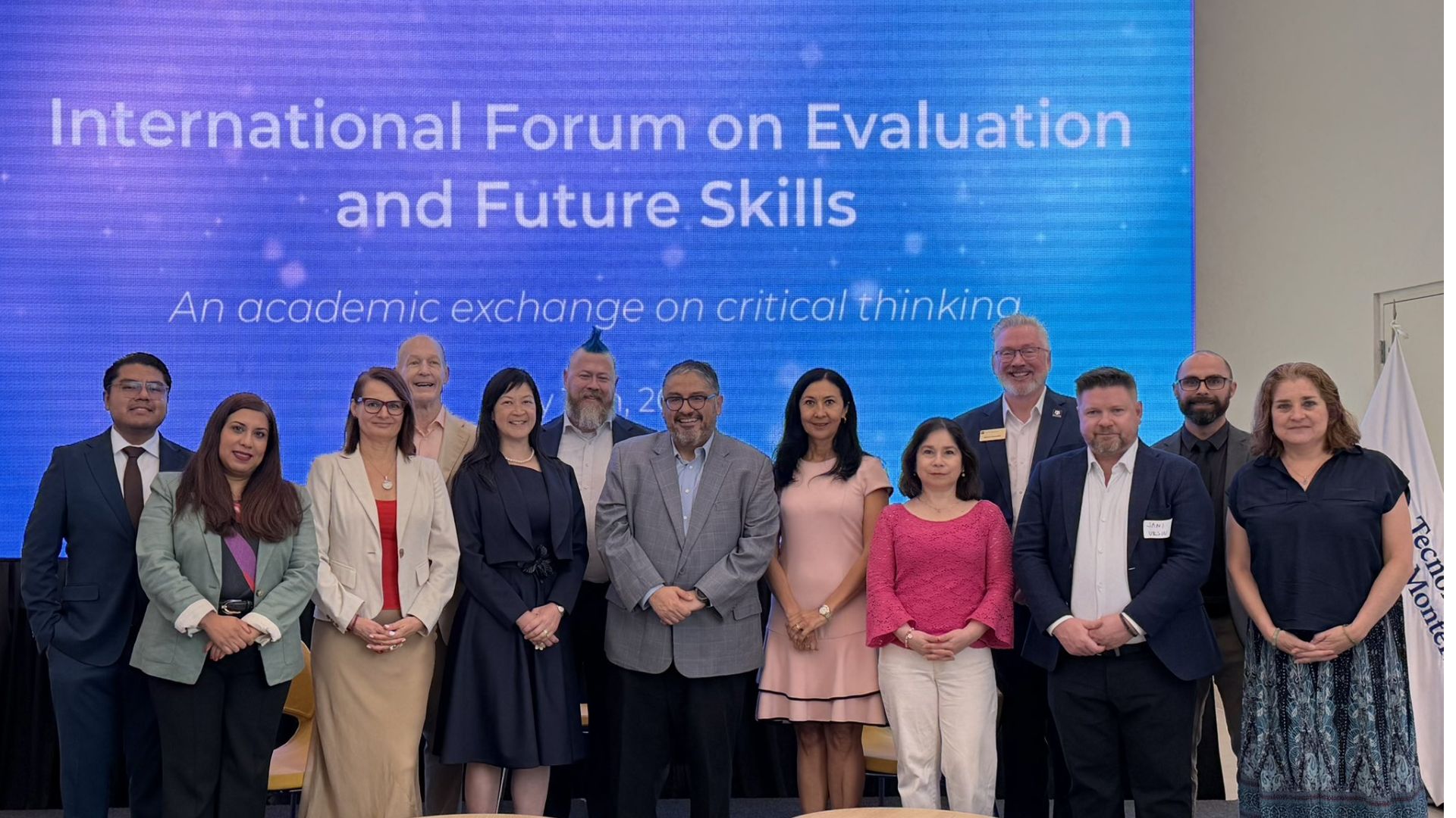 Grupo de especialistas y acad&eacute;micos posando frente a una pantalla del International Forum on Evaluation and Future Skills en el Tecnol&oacute;gico de Monterrey.