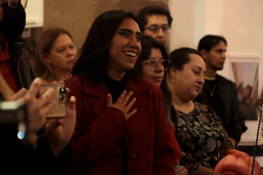 Artista con un gesto de aparente emoción al ser mencionada