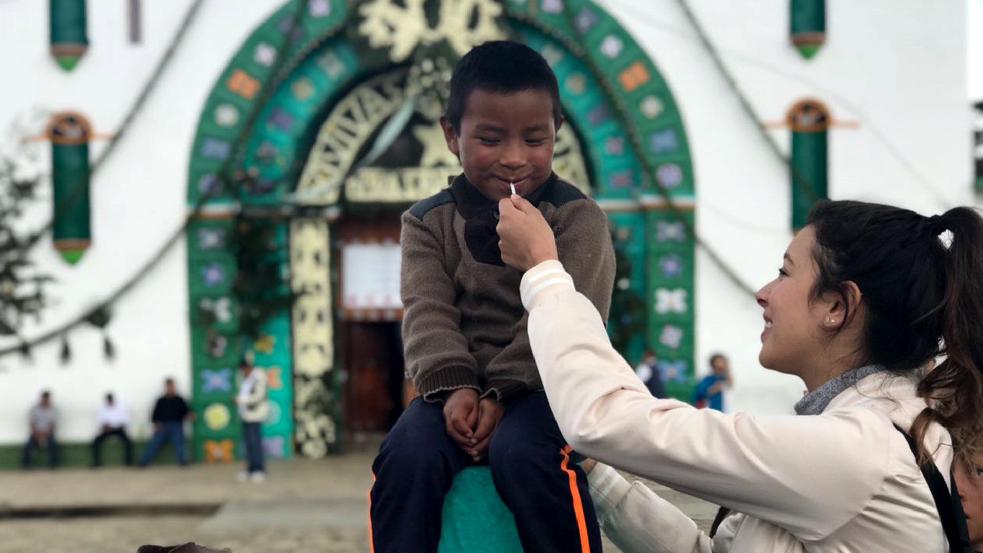 Joven dando paleta a niño chiapaneco