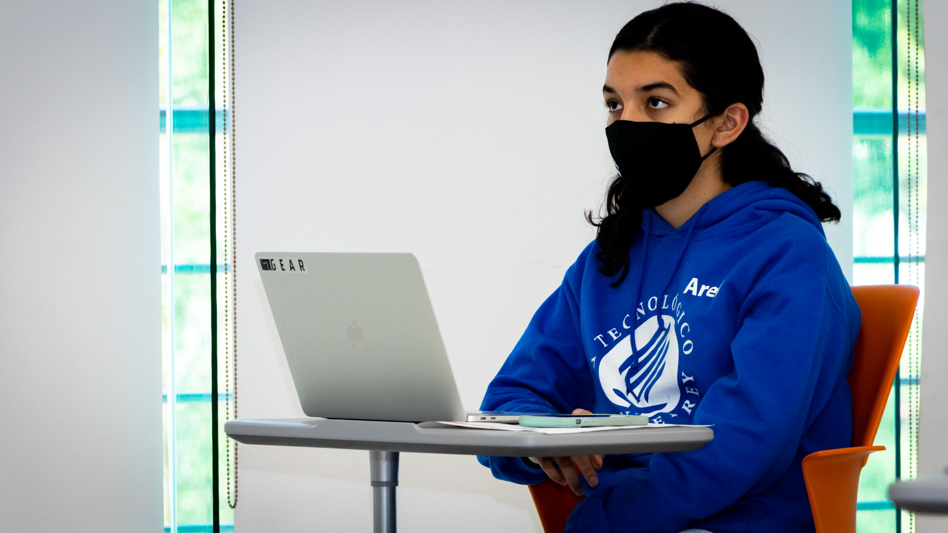 Alumna tomando clase híbrida y poniendo atención 