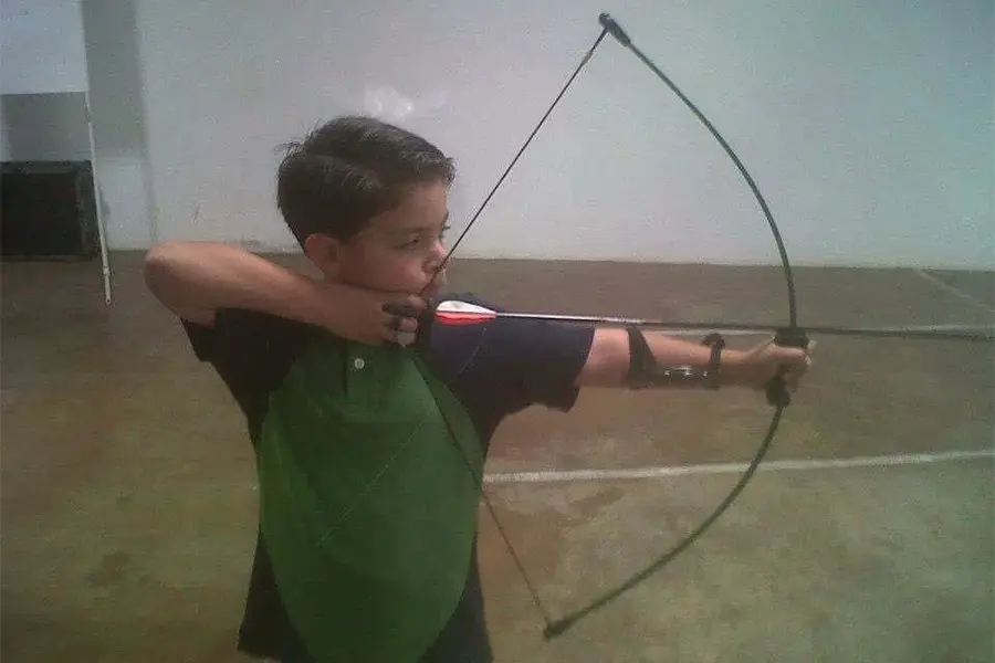 Arquero Hugo Cueto sosteniendo arco cuando era niño.
