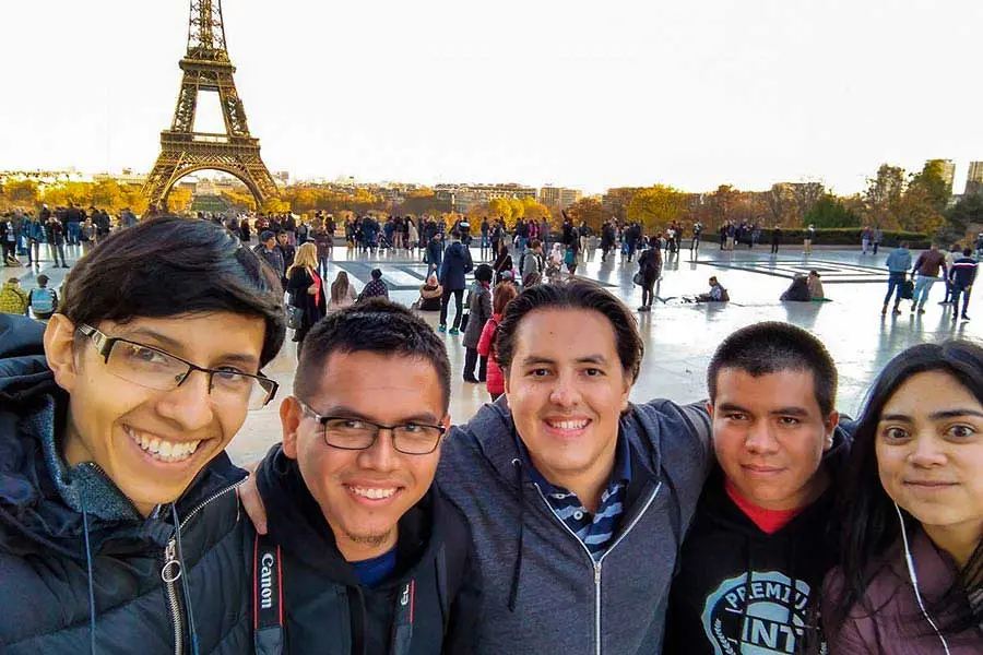 Azael junto a sus amigos frente a la Torre Eiffel