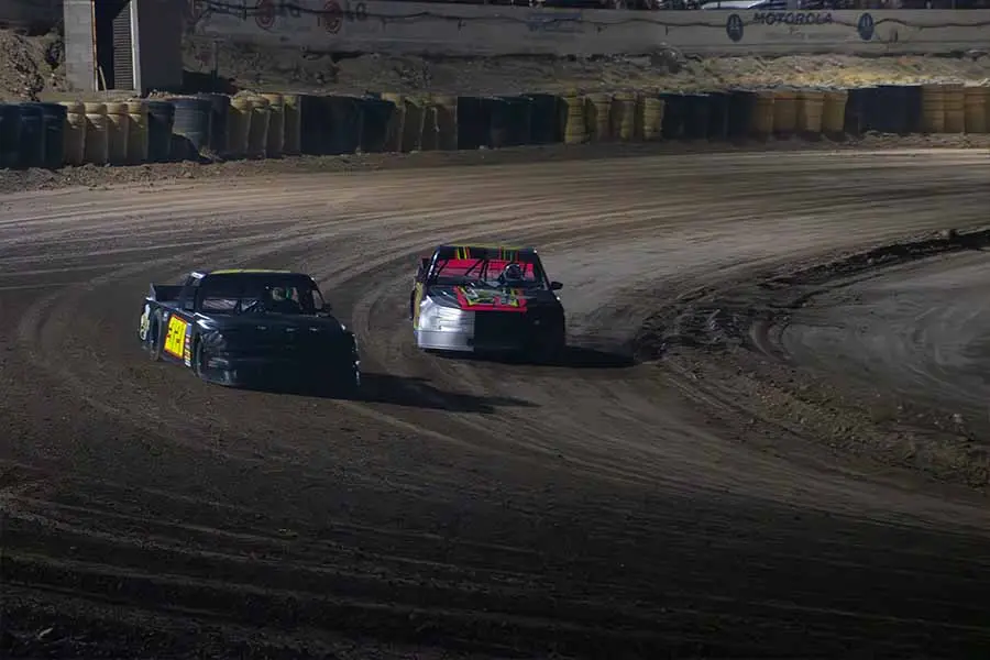 Dos carros corriendo sobre una pista de arcilla.