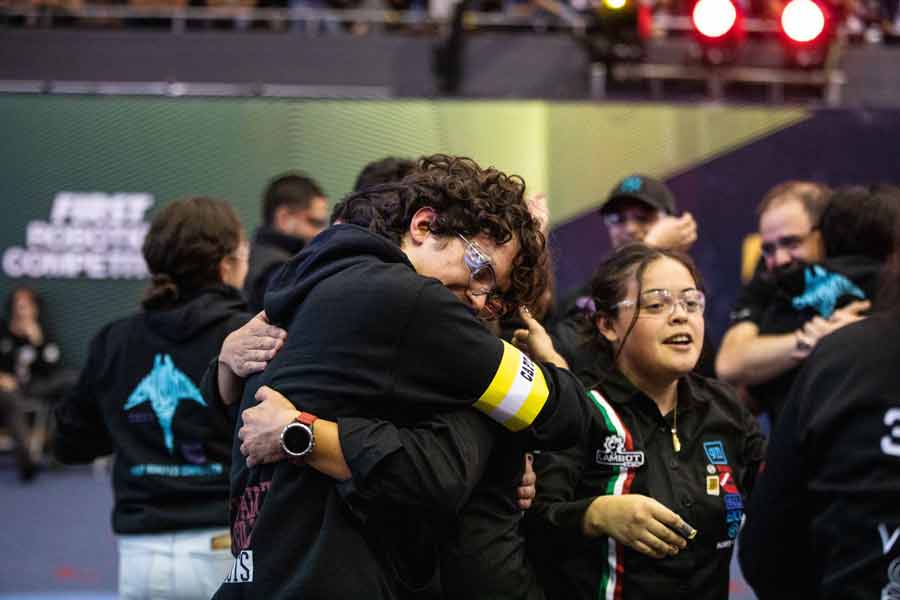 Miembros de Botbusters abrazándose y festejando su pase al mundial de FIRST durante el regional.