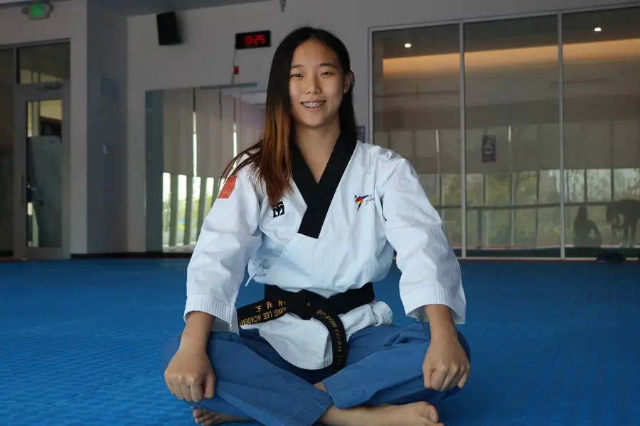 Cecilia Lee sentada en el área de taekwondo del Wellness Center.