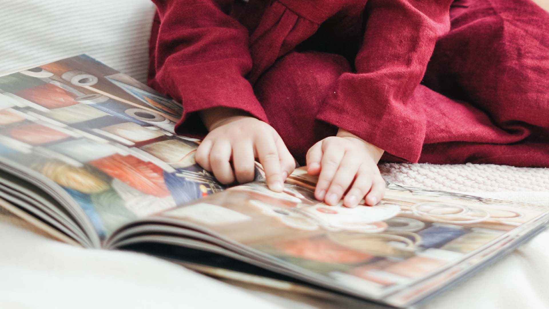 Manos de niño leyendo un libro