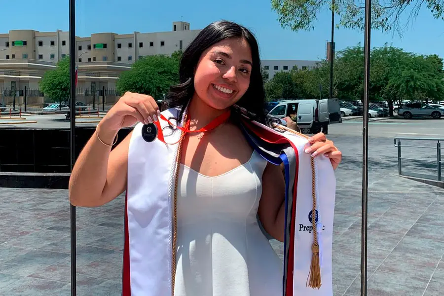 Egresada de PrepaTec Laguna posa para fotograf&iacute;a con sus estolas, medalla de liderazgo y cord&oacute;n de menci&oacute;n honor&iacute;fica de excelencia