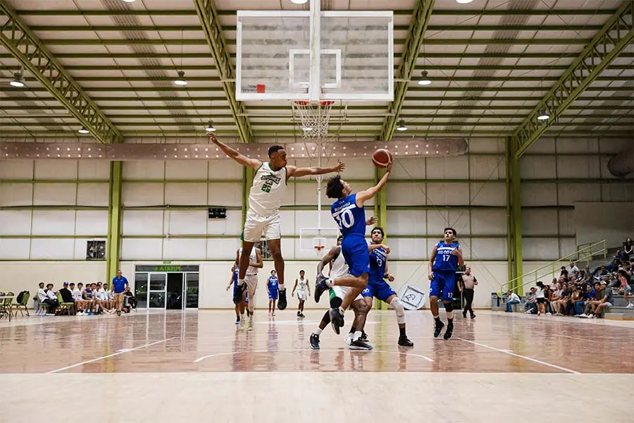 Jugador del equipo campeón de la Liga ADUL enero - junio 2025 de Borregos Laguna intenta encestar ante la defensa de un jugador de Halcones UAL