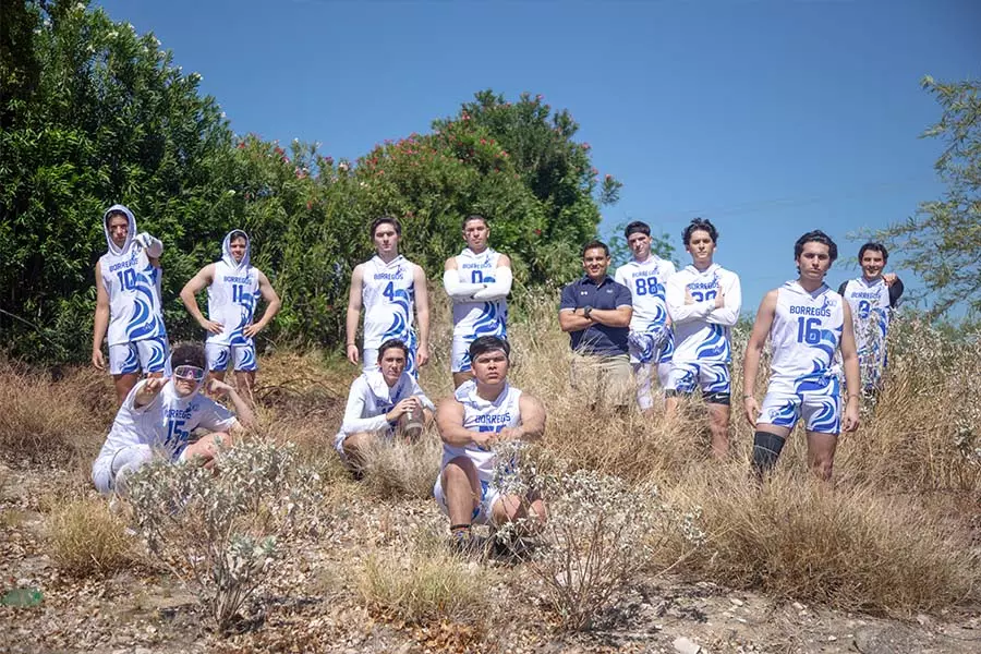 Equipo de fútbol flag varonil mayor del campus Sonora Norte posando junto con el coach Luis Carlos Martinez en el monte.