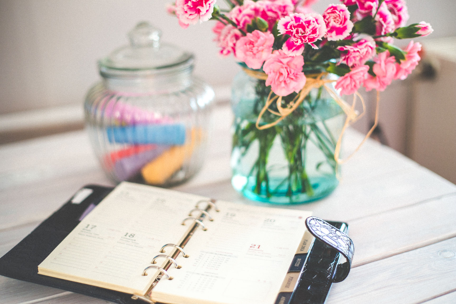 Escritorio con una agenda y como decoración un florero