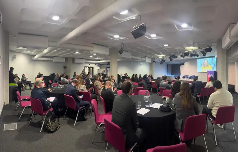 Personas en mesas de trabajo durante el foro