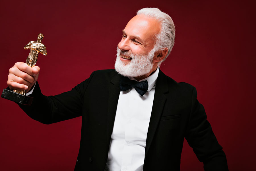 Hombre feliz sosteniendo estatuilla de premios oscar 2023