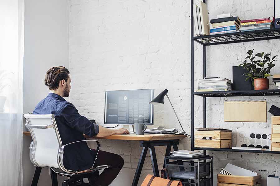 Joven trabajando desde su casa en la computadora