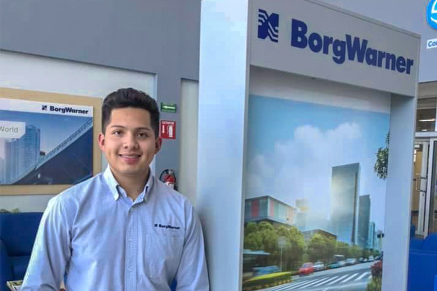 Fotografía de Humberto con un stand de BorgWarner de fondo.