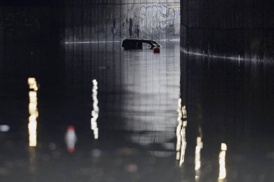 Un automóvil está casi bajo el agua en las aguas negras debajo de un paso subterráneo mientras se realizan trabajos de dragado después de una fuerte lluvia histórica en la Ciudad de México,