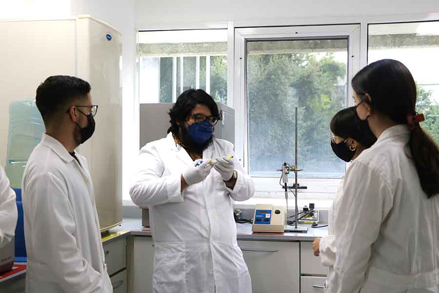 Profesor y estudiantes en prácticas de laboratorio.