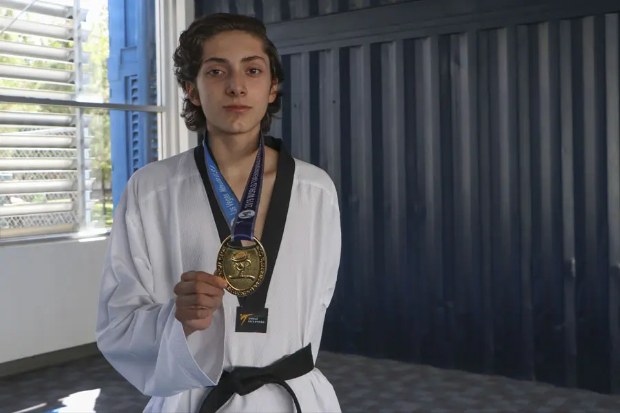 Luis mostrando su medalla de oro de competencia en taekwondo. 