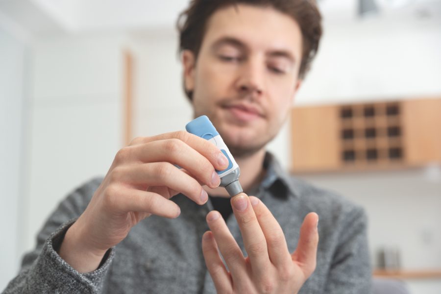 Hombre joven tomando medición de glucosa