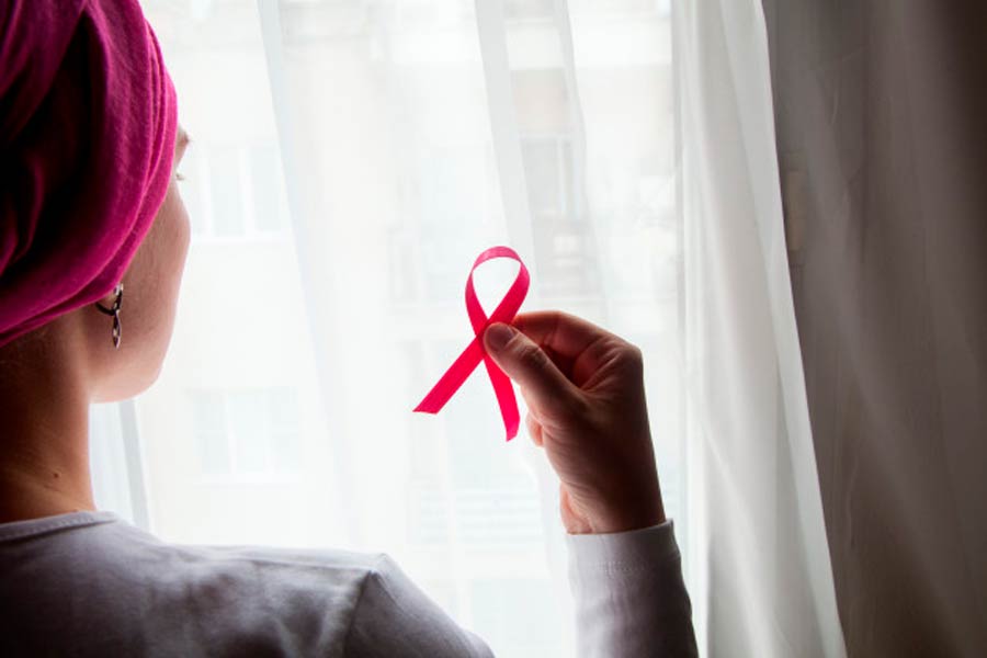 Mujer portando listón rosa, prevención cáncer de mama