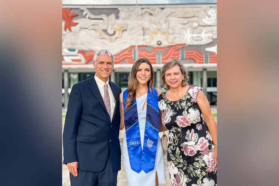 Natalia Orozco alumna destacada del campus Monterrey y sus papás frente al Mural de Rectoría