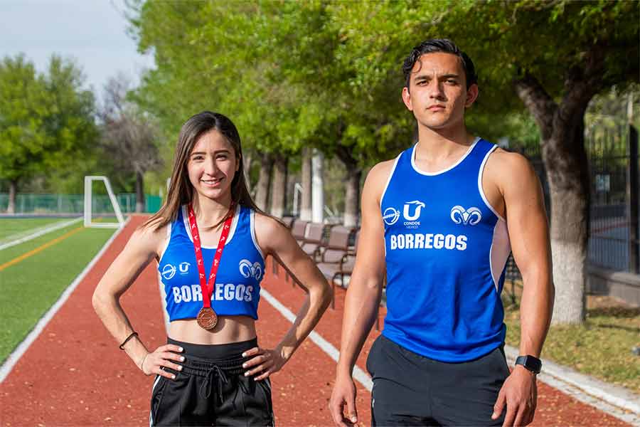 Sofia y Carlos con uniforme de atletismo en la cancha