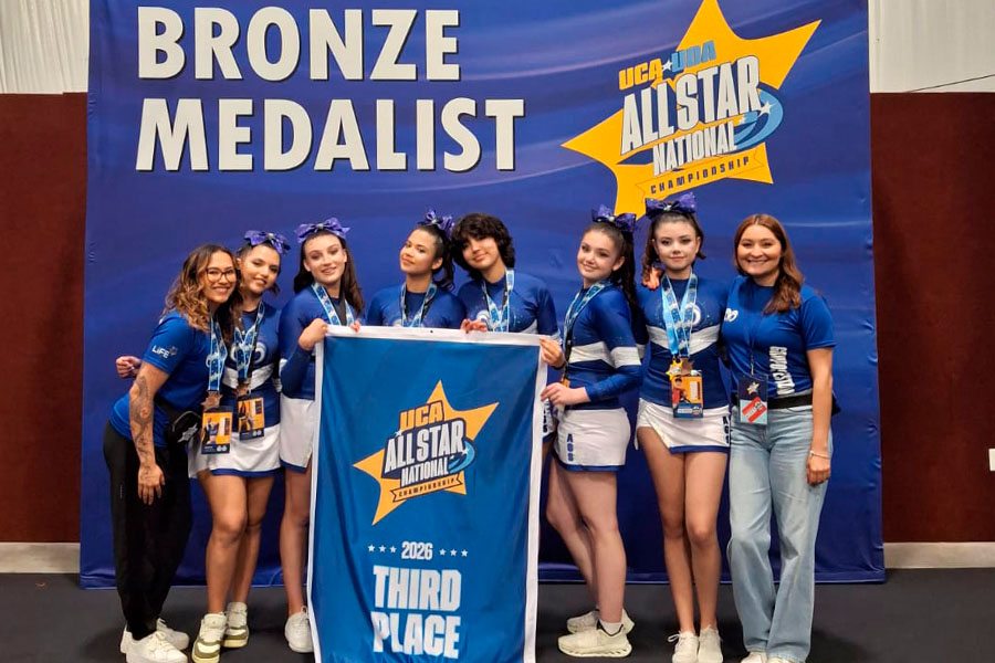 Equipo sosteniendo su bander&iacute;n de tercer lugar