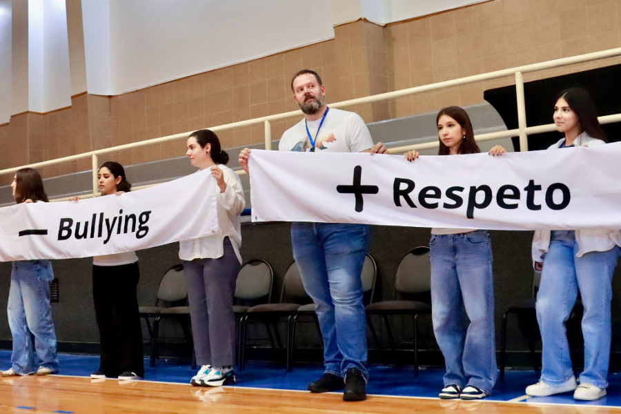 Docente y estudiantes de PrepaTec Chihuahua sostienen cartel de menos Bullying y m&aacute;s respeto en la presentaci&oacute;n del programa Olweus. 
