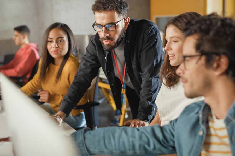 profesor colaborando con estudiantes