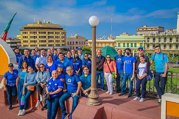 profesores posando con la plaza de la libertad de fondo