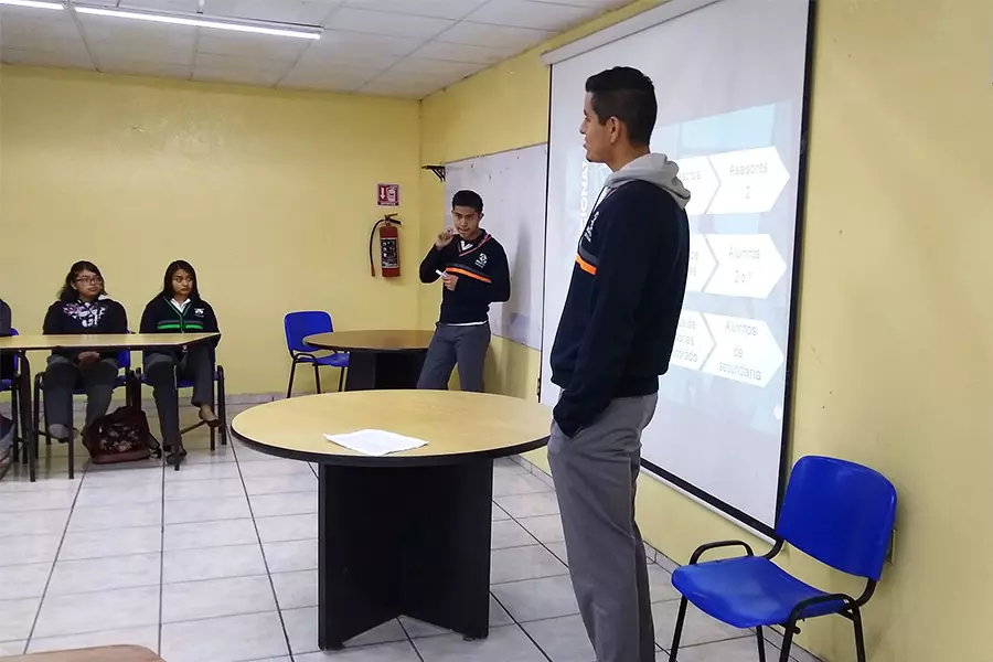 Sebastián frente a un grupo de alumnos, presentando una conferencia de PERMA