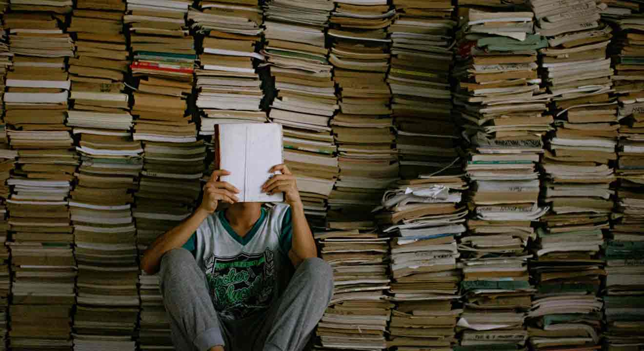 Niño sentado frente a libros