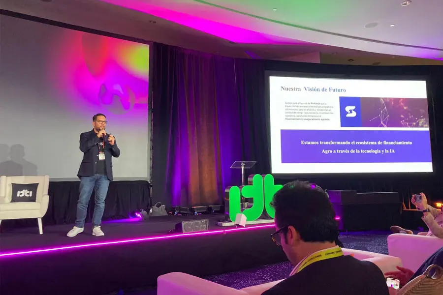 Profesor en escenario presentando su empresa en concurso Pitch Off.