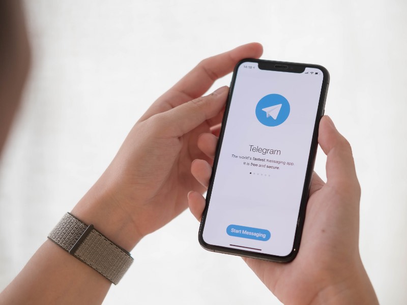 Mano sosteniendo teléfono con Telegram