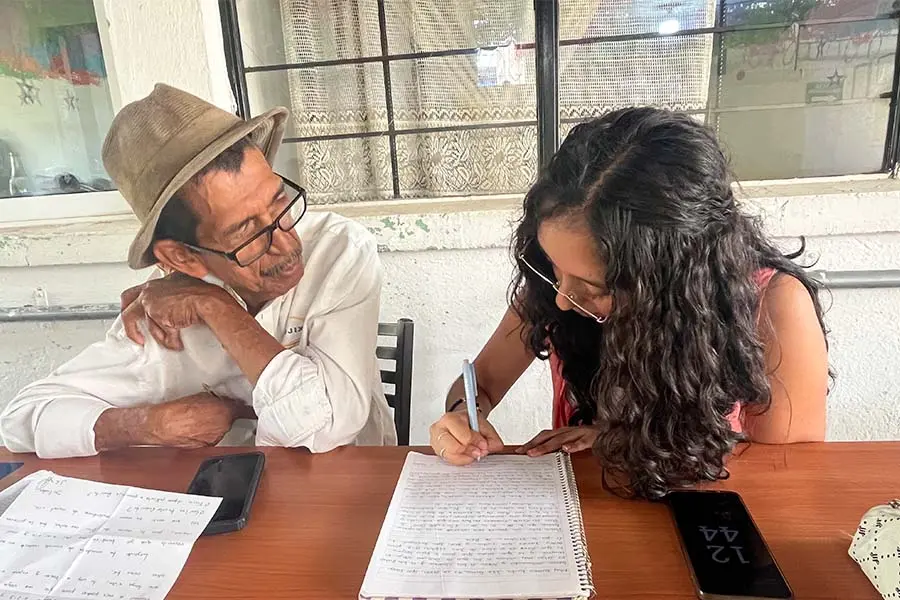 Valeria ayuda a un adulto mayor a escribir su carta