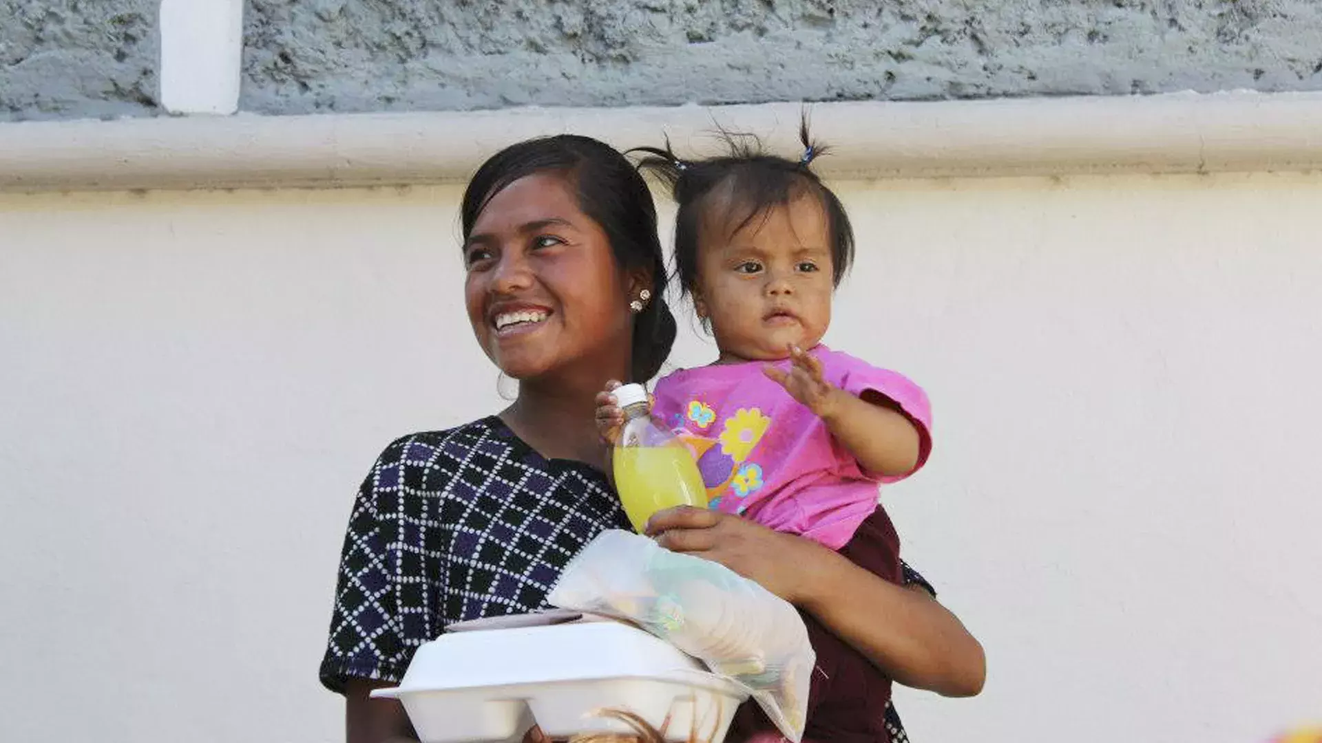 una señora y su pequeña hija después de recibir la ayuda