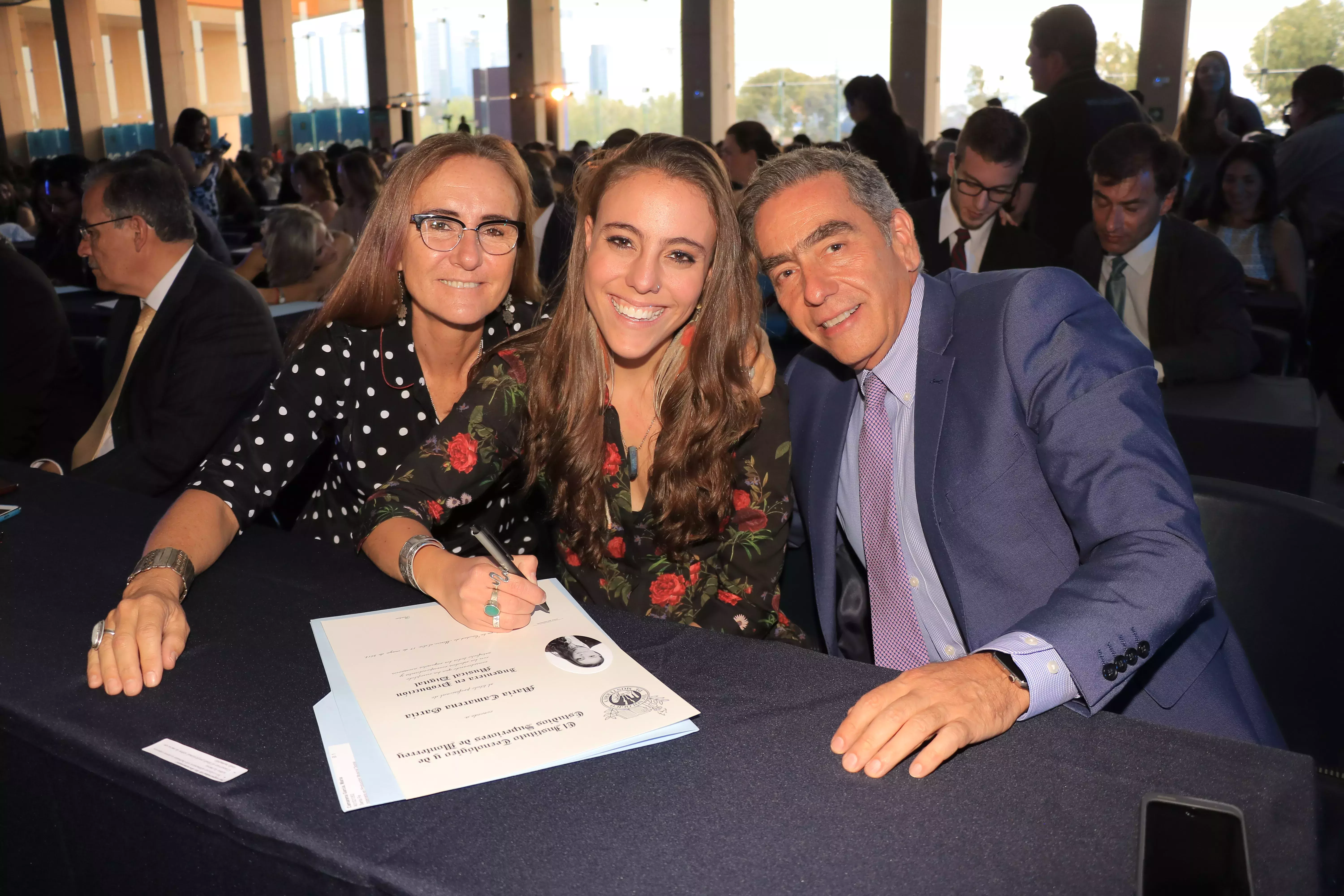 Alumna firmando su título.