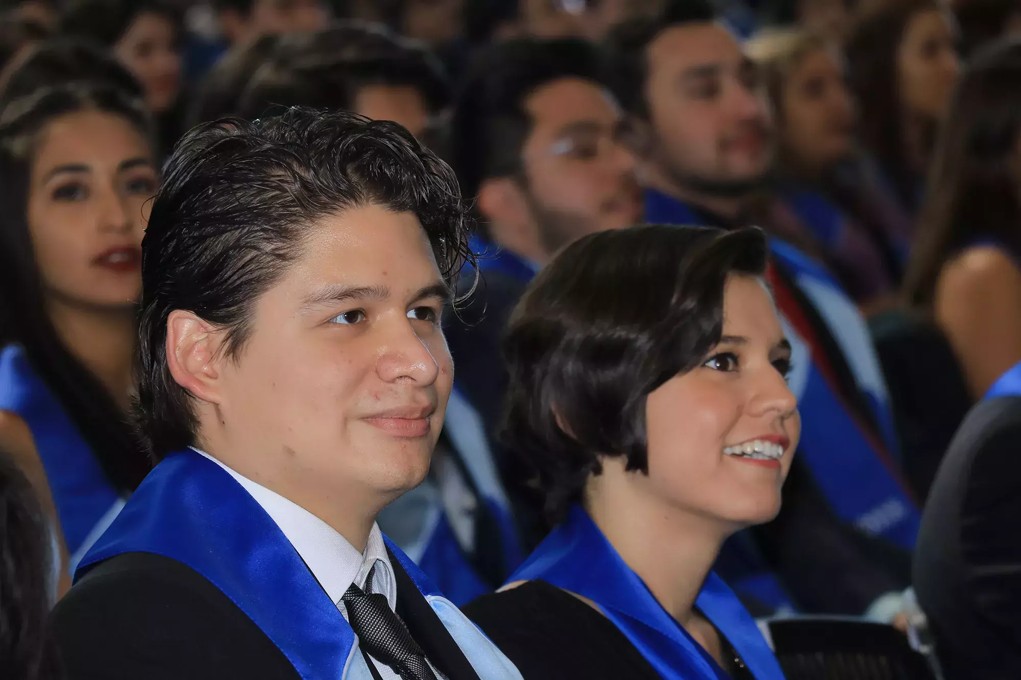 alumnos escuchando el mensaje de graduación