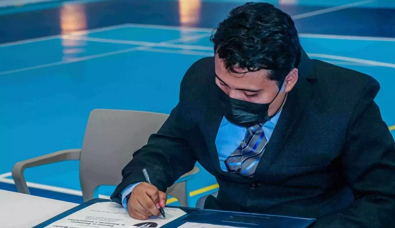 Alumno firmando su título profesional.