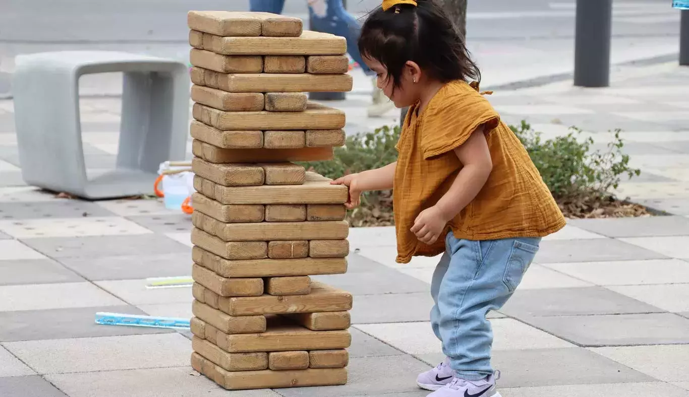 Una niña jugando jenga.