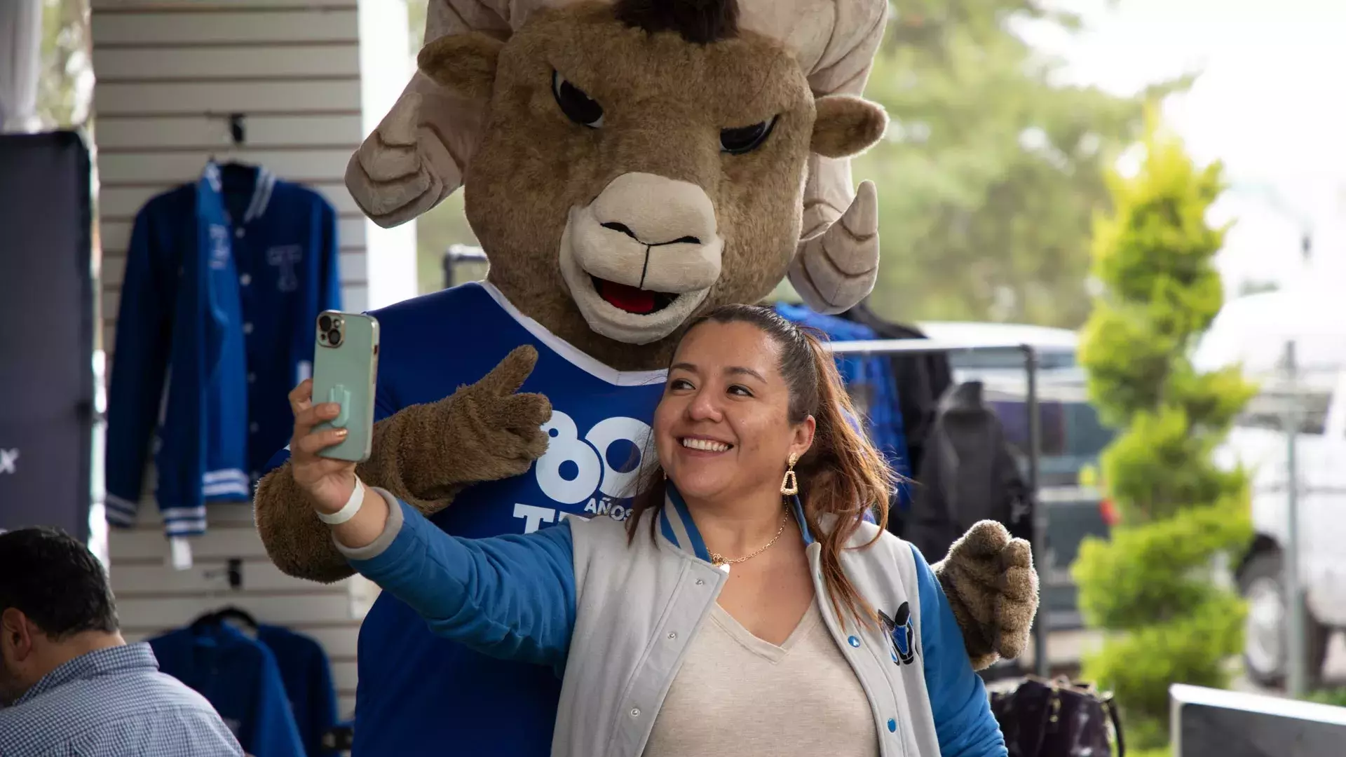 Mujer tomándose foto con Teus, la mascota del Tec