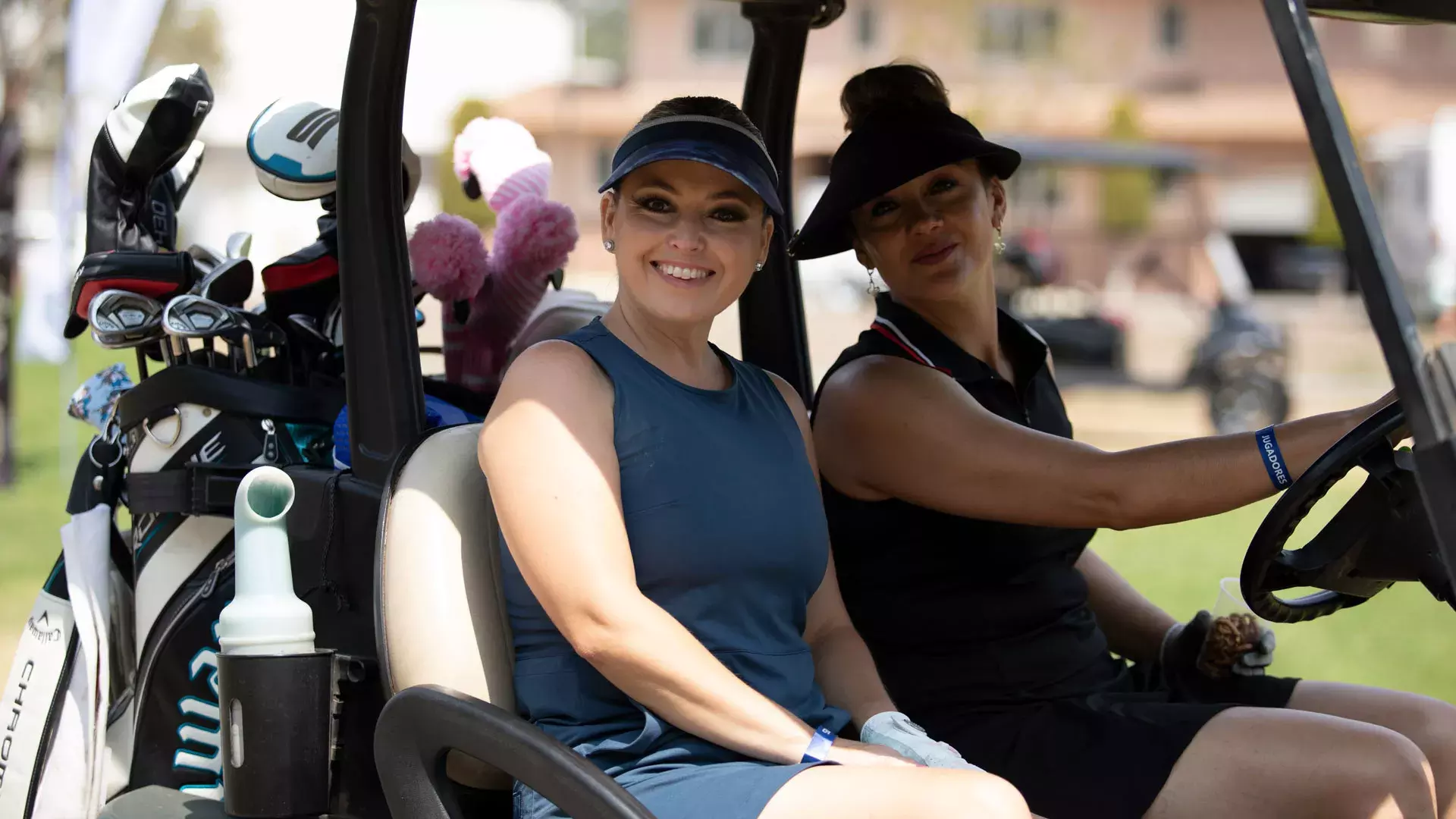 Golfistas mujeres sonriendo en un carro del golf