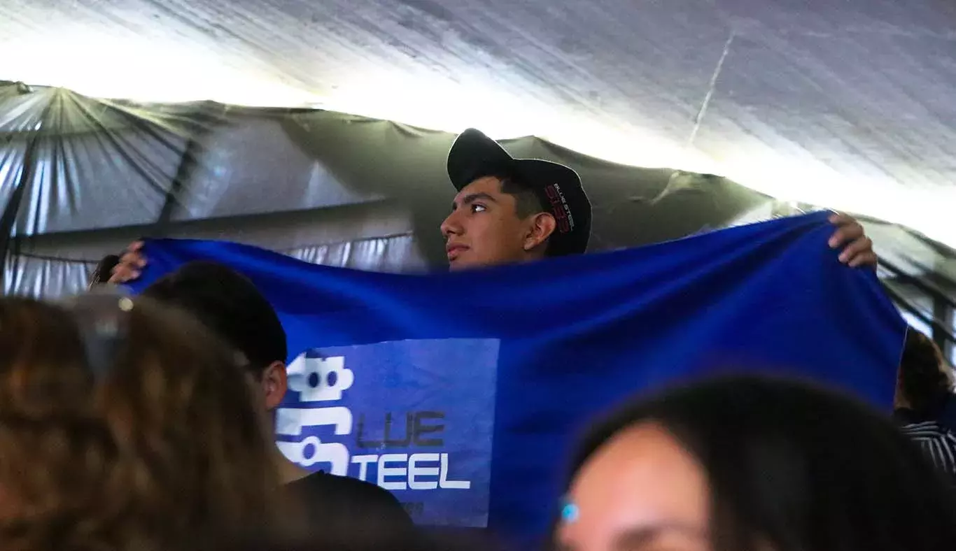 Estudiante sosteniendo la bandera del equipo