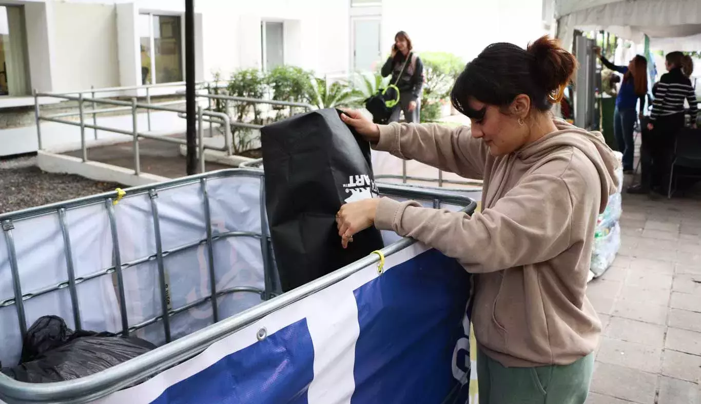 Mujer deja latas en depósitos de Reciclatec.