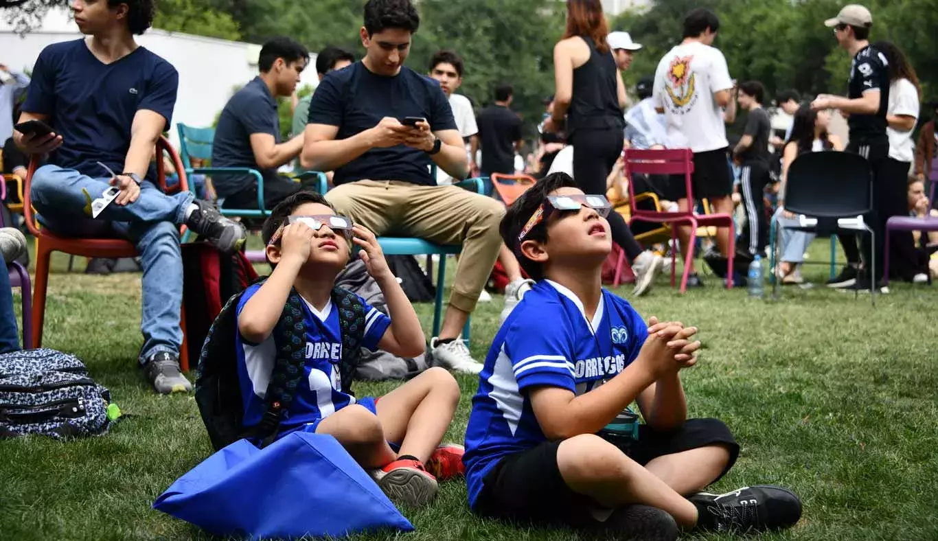 Dos niños viendo el eclipse solar desde Jardín de las Carreras.