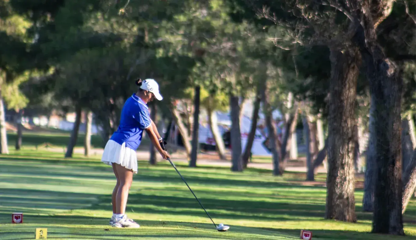 Jugadora preparando su tiro en uno de los hoyos del recorrido.